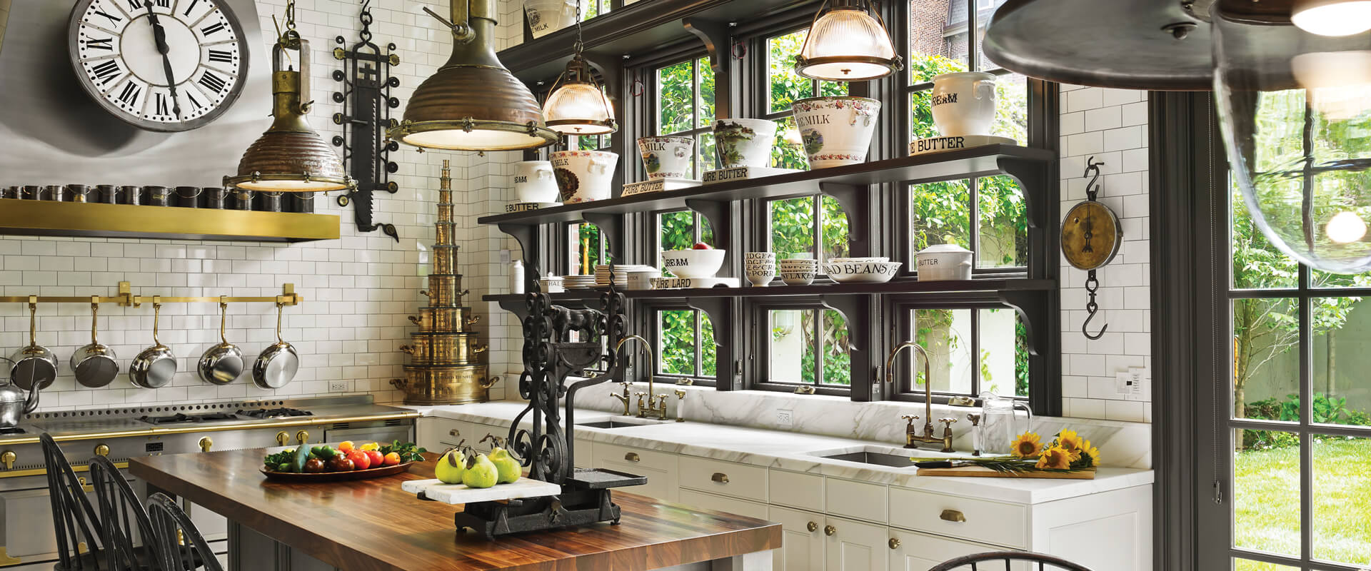 Many stationary picture and transom windows stacked over Ultra Series crank-out awning windows behind a kitchen counter.